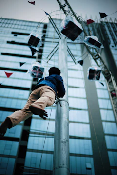 A skilled climber performing professional minaret painting using rope access techniques.