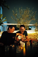 Couple sharing a laugh over candlelight dinner in a stylish hotel room.