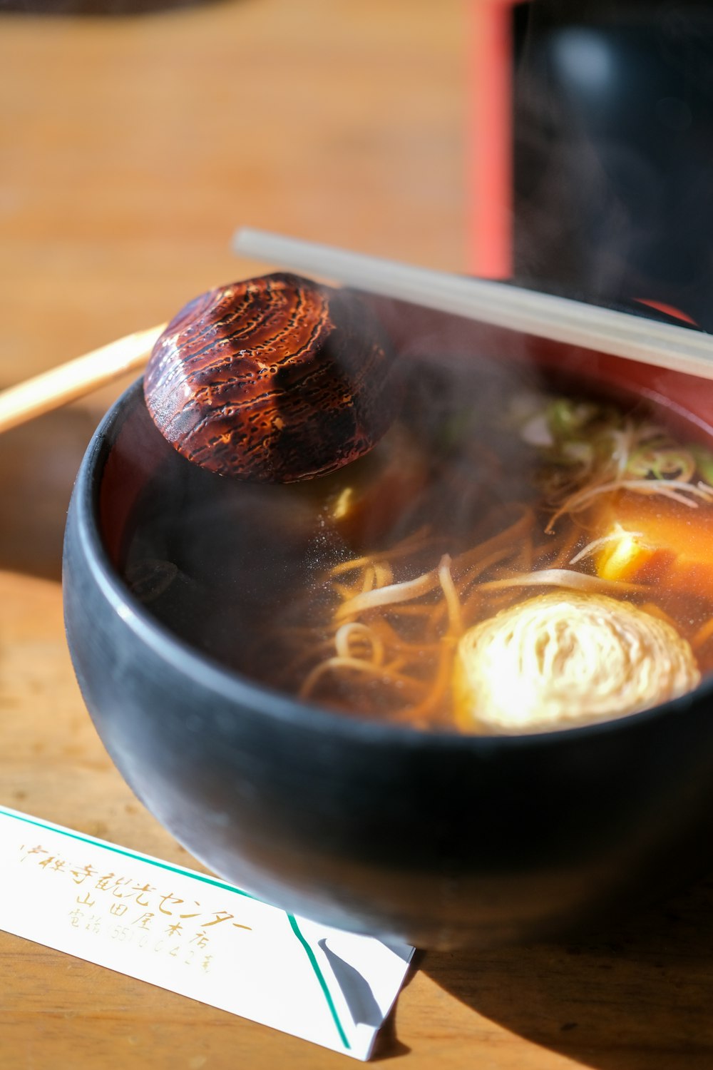 a bowl of soup and chopsticks on a table