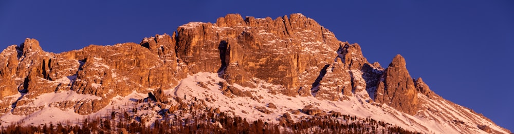 a snow covered mountain with a blue sky in the background