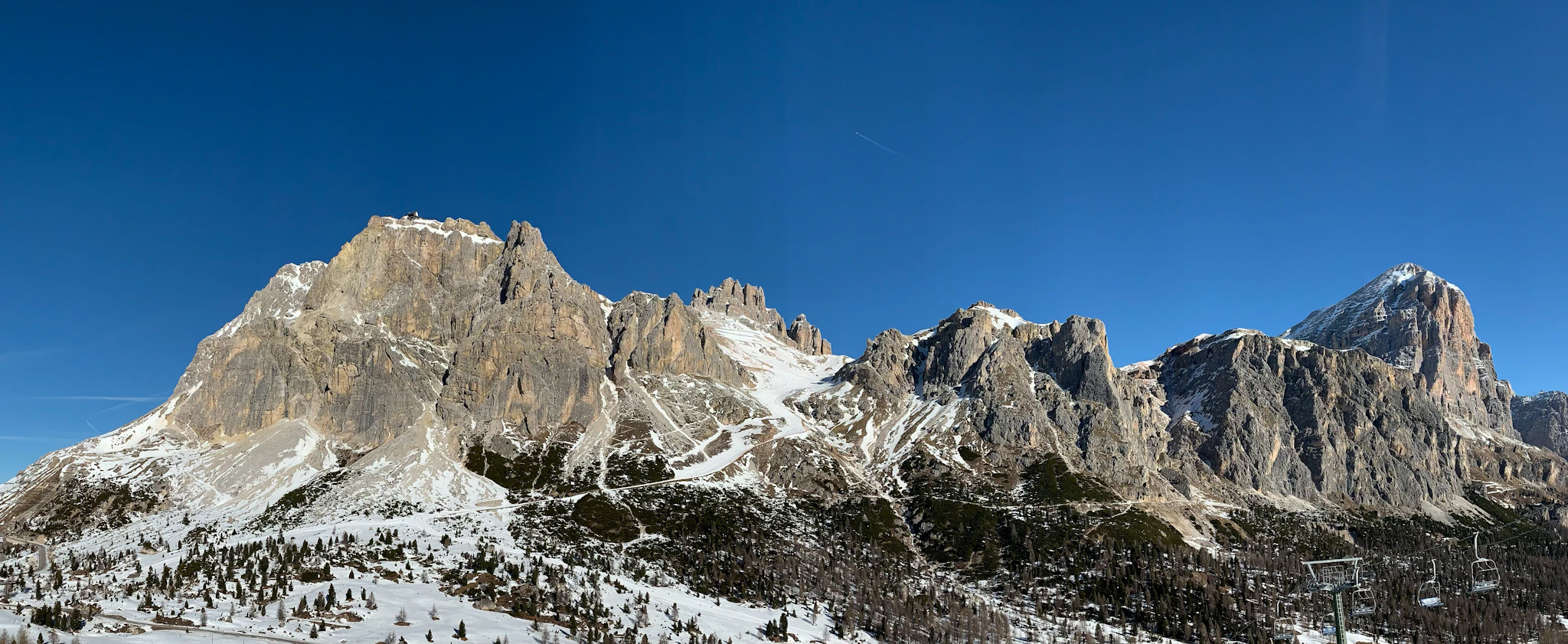 A ski lift in front of snowy Dolomite peaks, skiing Cortina d'Ampezzo