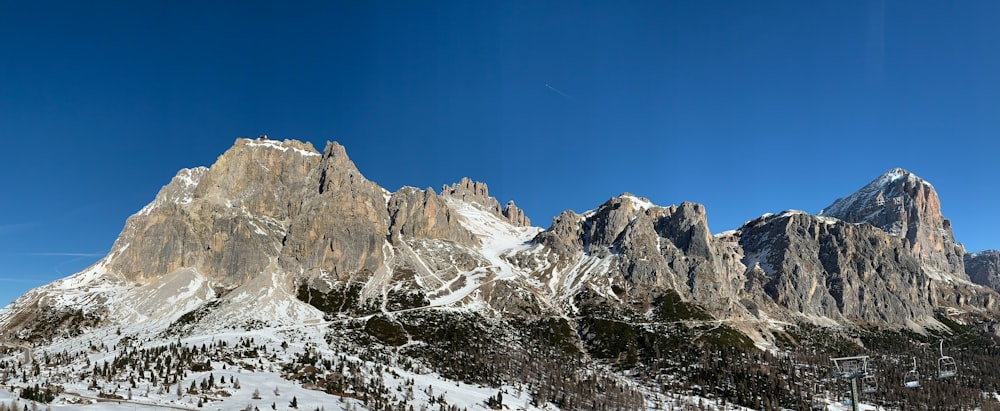 a snow covered mountain with a ski lift in the foreground