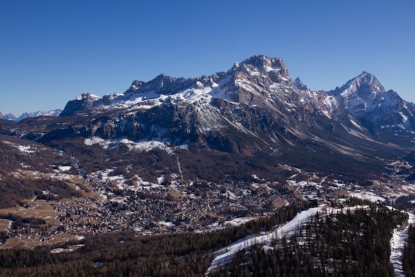 Aerial view of snow-covered Cortina d'Ampezzo spread across its basin beneath Dolomite peaks