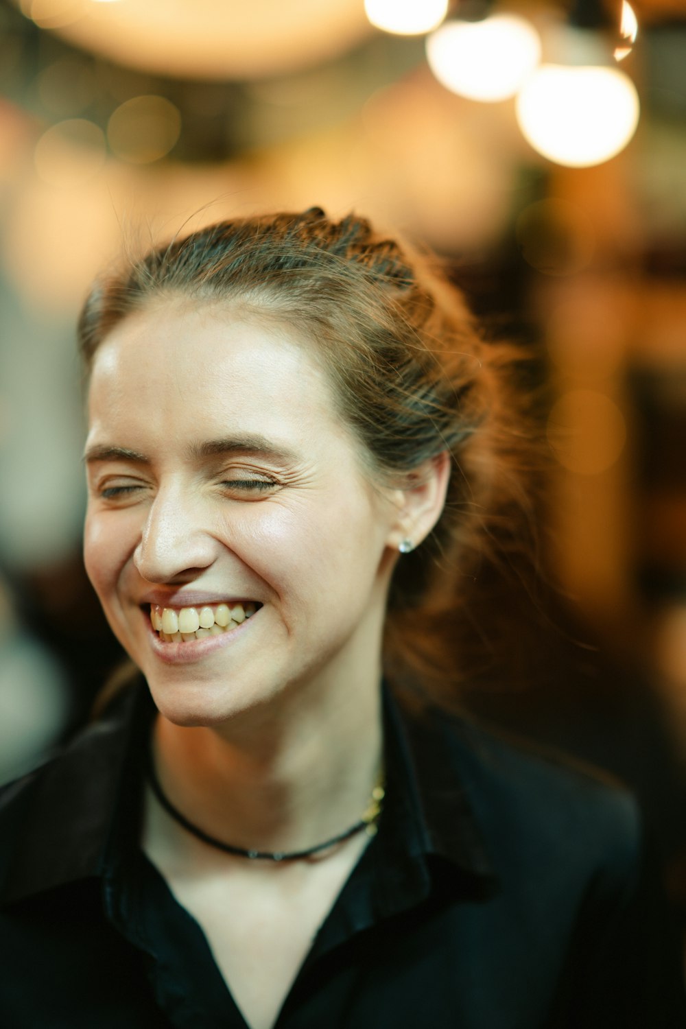 a woman smiling and wearing a black shirt