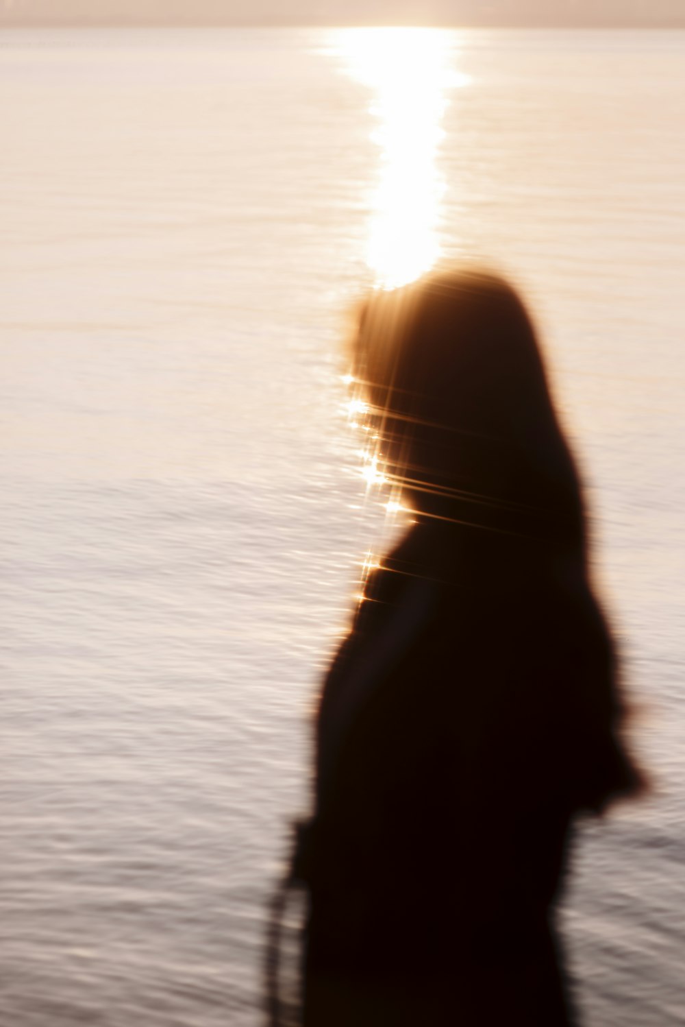 a blurry photo of a person standing in front of a body of water