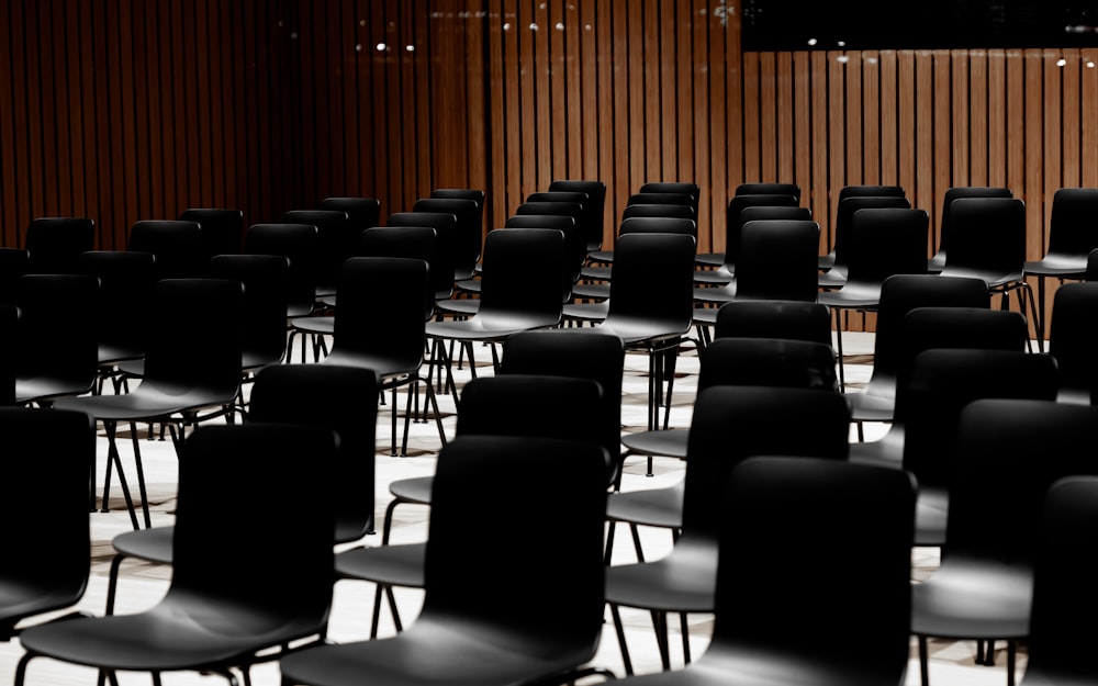 a room filled with lots of black chairs