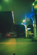 Night view of the fuel station illuminated with green and gray lights.
