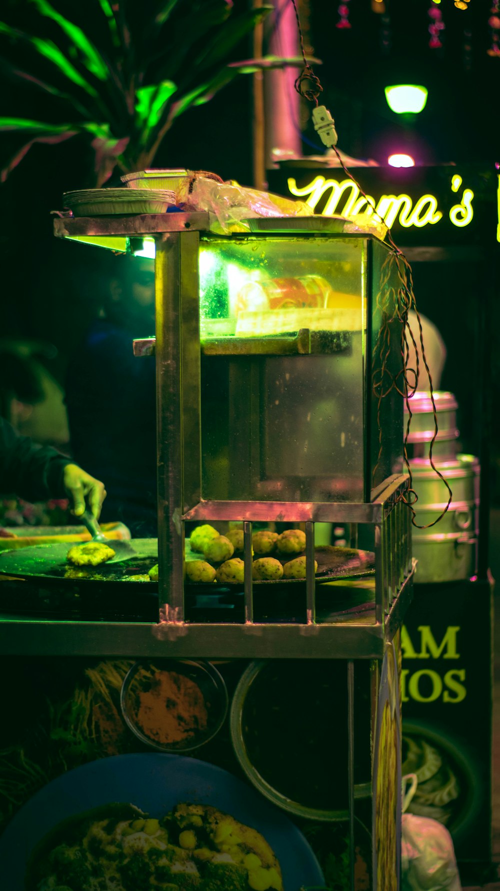 a food stand with a neon sign in the background
