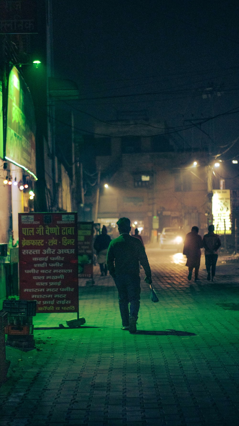 a man walking down a street at night