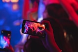 Close-up of a camera lens capturing a live music performance.
