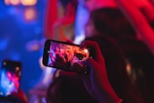 Close-up of a camera capturing a live concert with vibrant crowd energy.