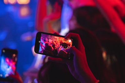 A close-up of mentraos AI glasses capturing a vibrant outdoor concert.
