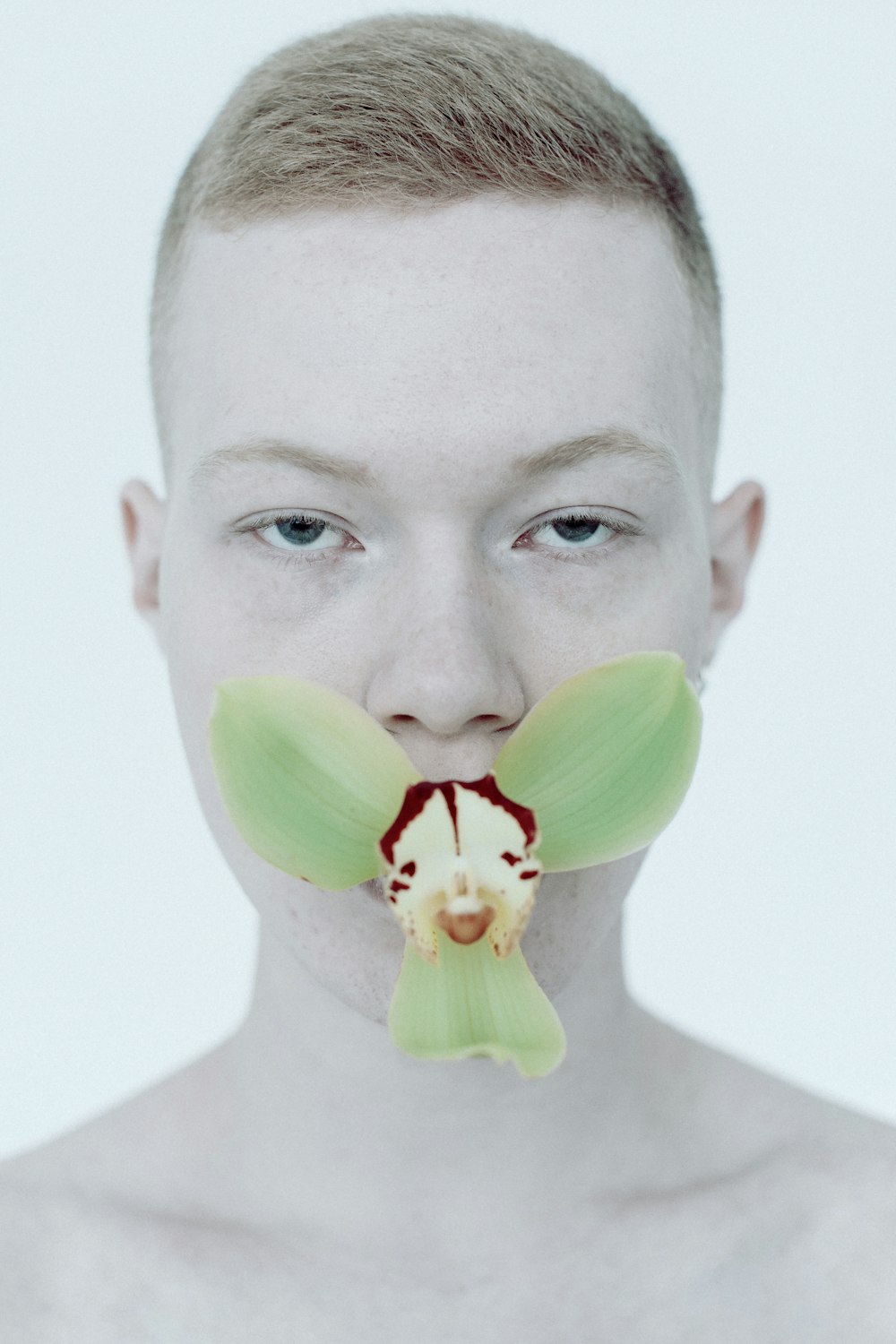 Un hombre con una flor en la boca