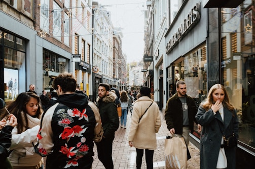 People browsing shops in a bustling city street.