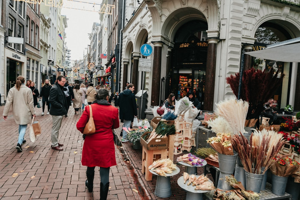 a woman in a red coat walking down a street