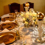 An elegant banquet table set with floral centerpieces and golden accents.