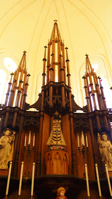 An altar adorned with candles, herbs, and carved wooden symbols of ancient gods.