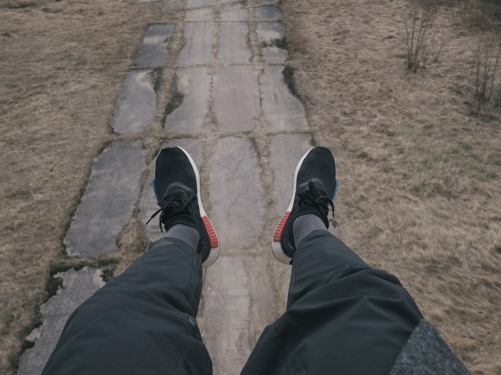 a person standing on a walkway with their feet in the air