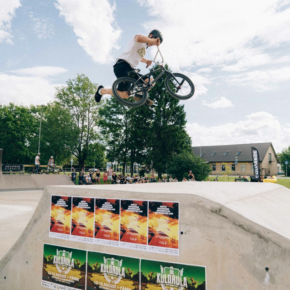 a man riding a bike up the side of a ramp