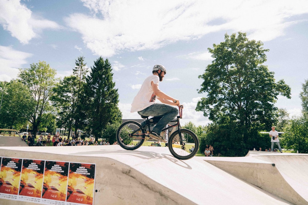 a man riding a bike up the side of a ramp