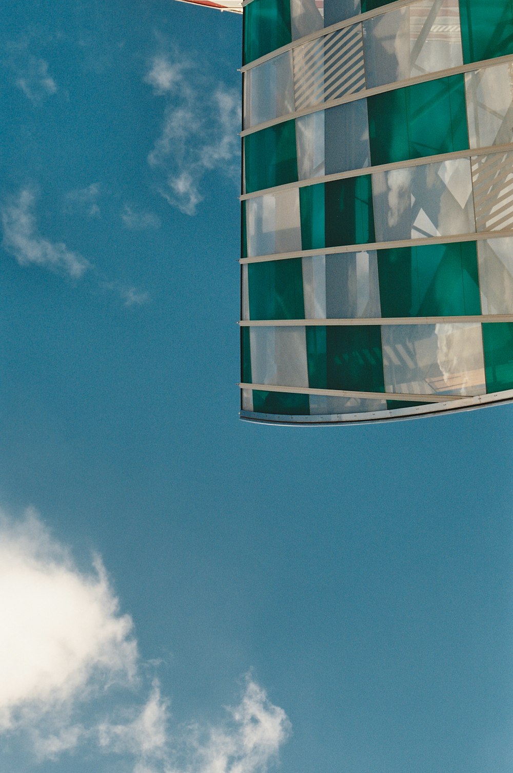 a green and white flag flying in the sky