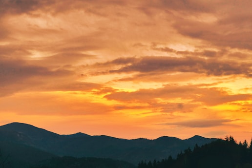 A scenic view of the mountains in Jujuy at sunset, with vibrant colors in the sky.