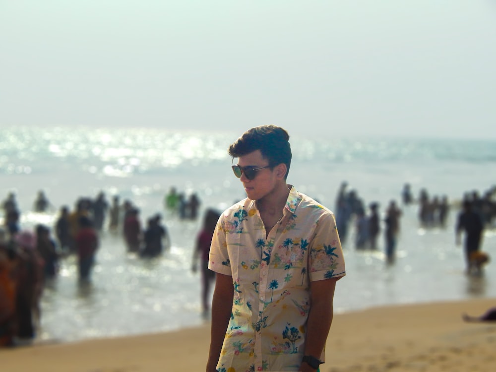 a man standing on top of a beach next to the ocean