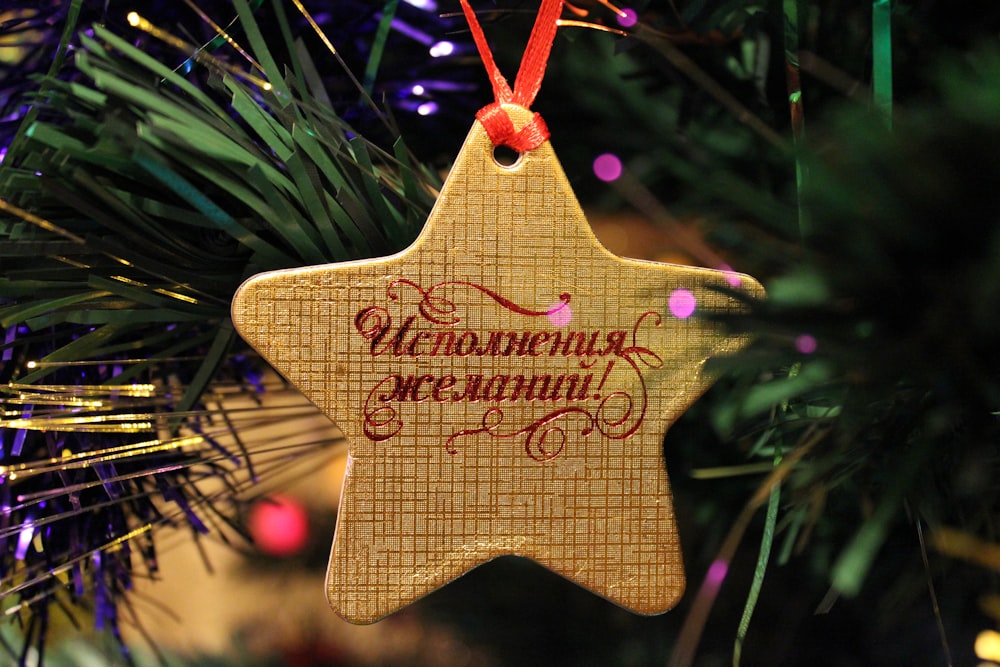 a wooden star ornament hanging from a christmas tree