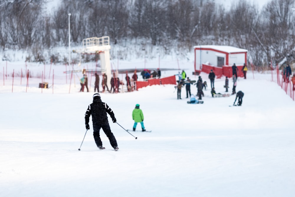 a group of people riding skis down a snow covered slope