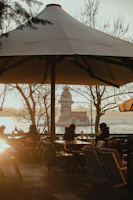 A serene seaside cafe at sunset with warm lights reflecting on the water