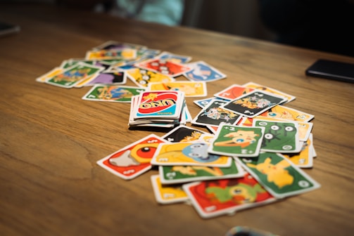A colorful blind box toy spilling out character cards on a wooden table.