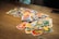 A close-up of vibrant flashcards spread out on a table with children's hands reaching for them.
