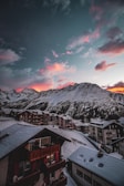 Sunset over a mountain village nestled among snowy slopes.