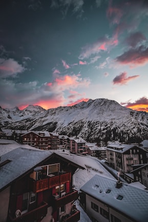 Sunset over a mountain village nestled among snowy slopes.