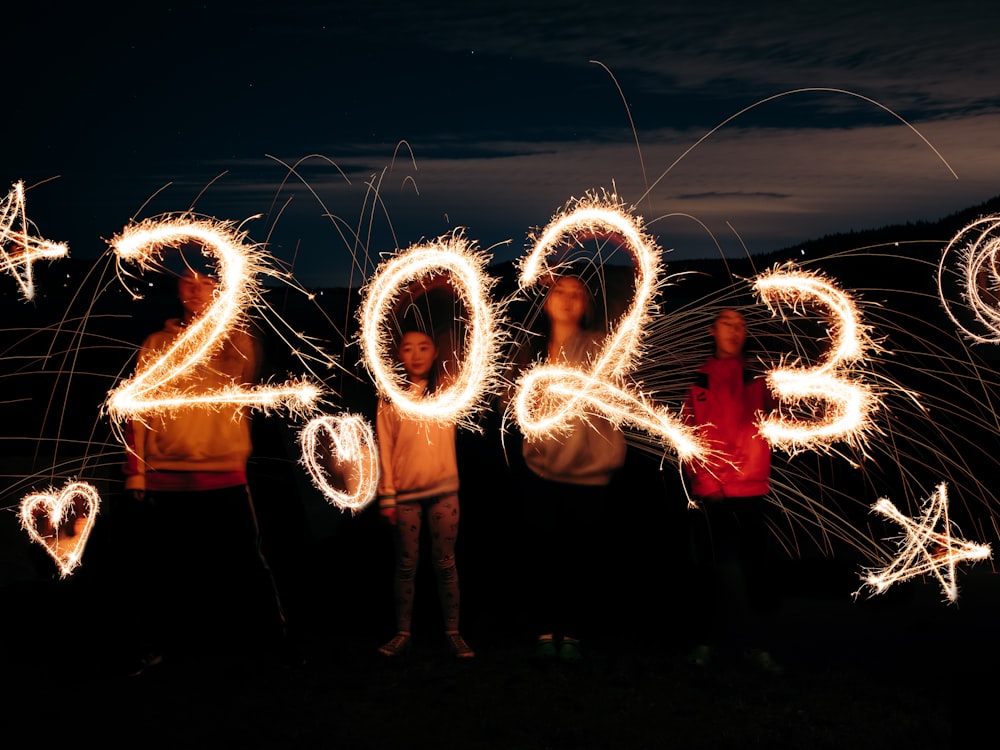 a group of people standing next to each other holding sparklers