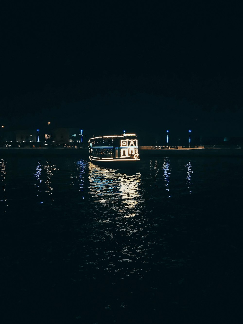 a boat floating on top of a body of water at night