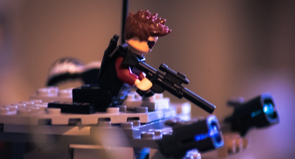 a lego man with a gun on top of a table