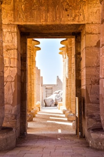 an archway leading to a building with statues on it