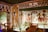 A richly decorated ancient Egyptian tomb with intricate hieroglyphs and colorful wall paintings featuring deities and symbolic figures. The room is illuminated by strategic lighting, showcasing the detail of the artwork and architectural features, including carved pillars and ornate borders.