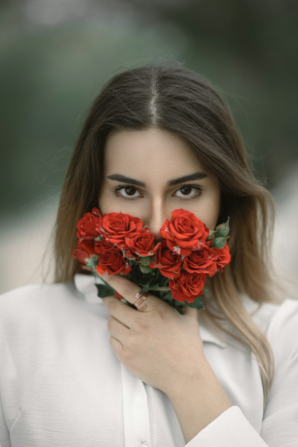 a woman holding a bunch of red roses