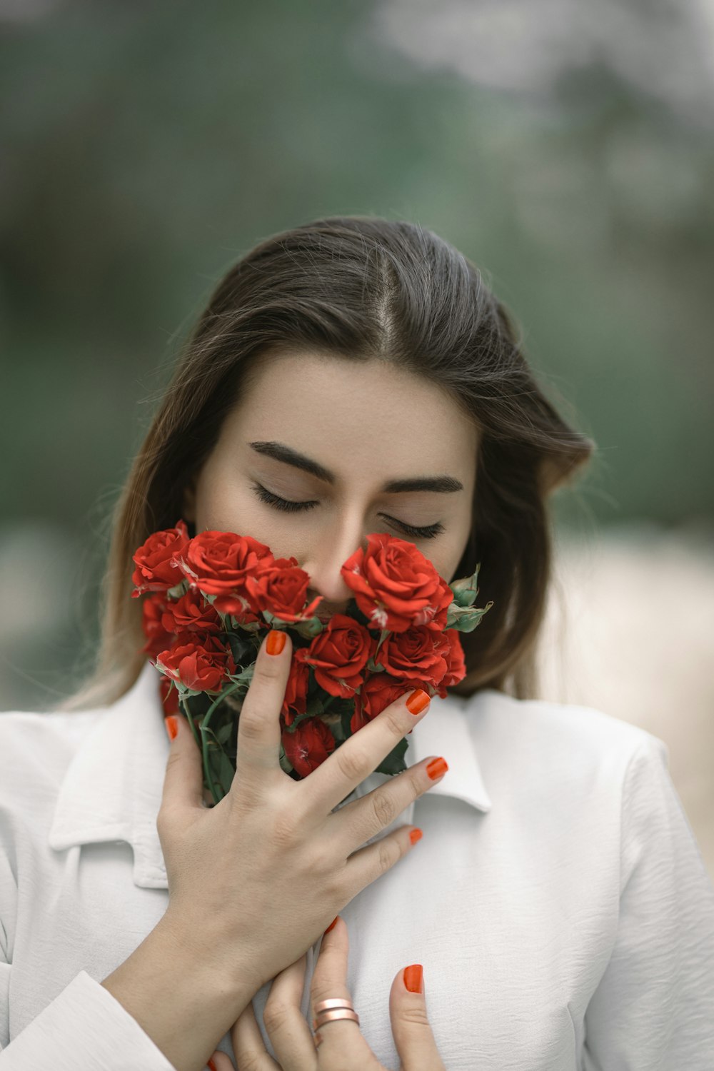 a woman holding a bunch of red roses