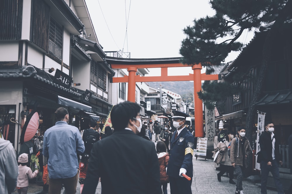 a group of people walking down a street next to tall buildings