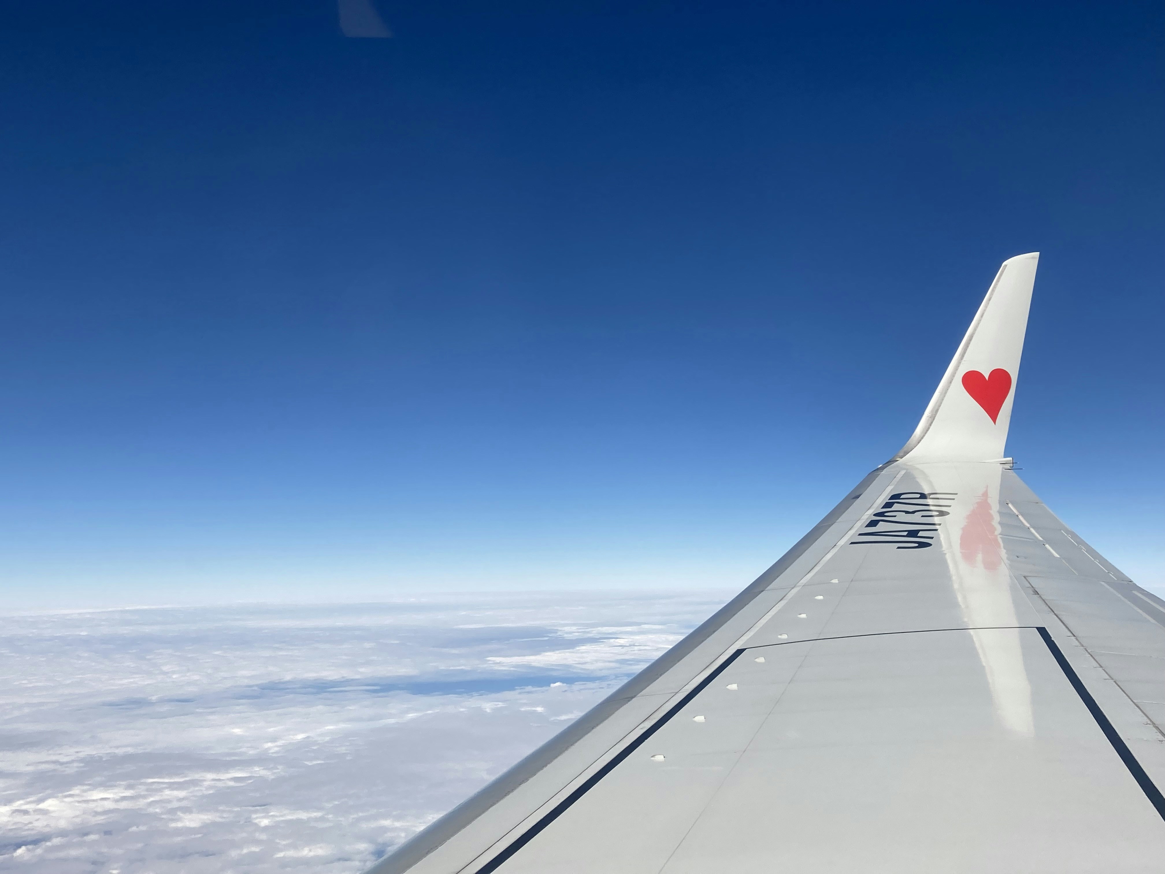l’aile d’un avion avec un cœur peint dessus