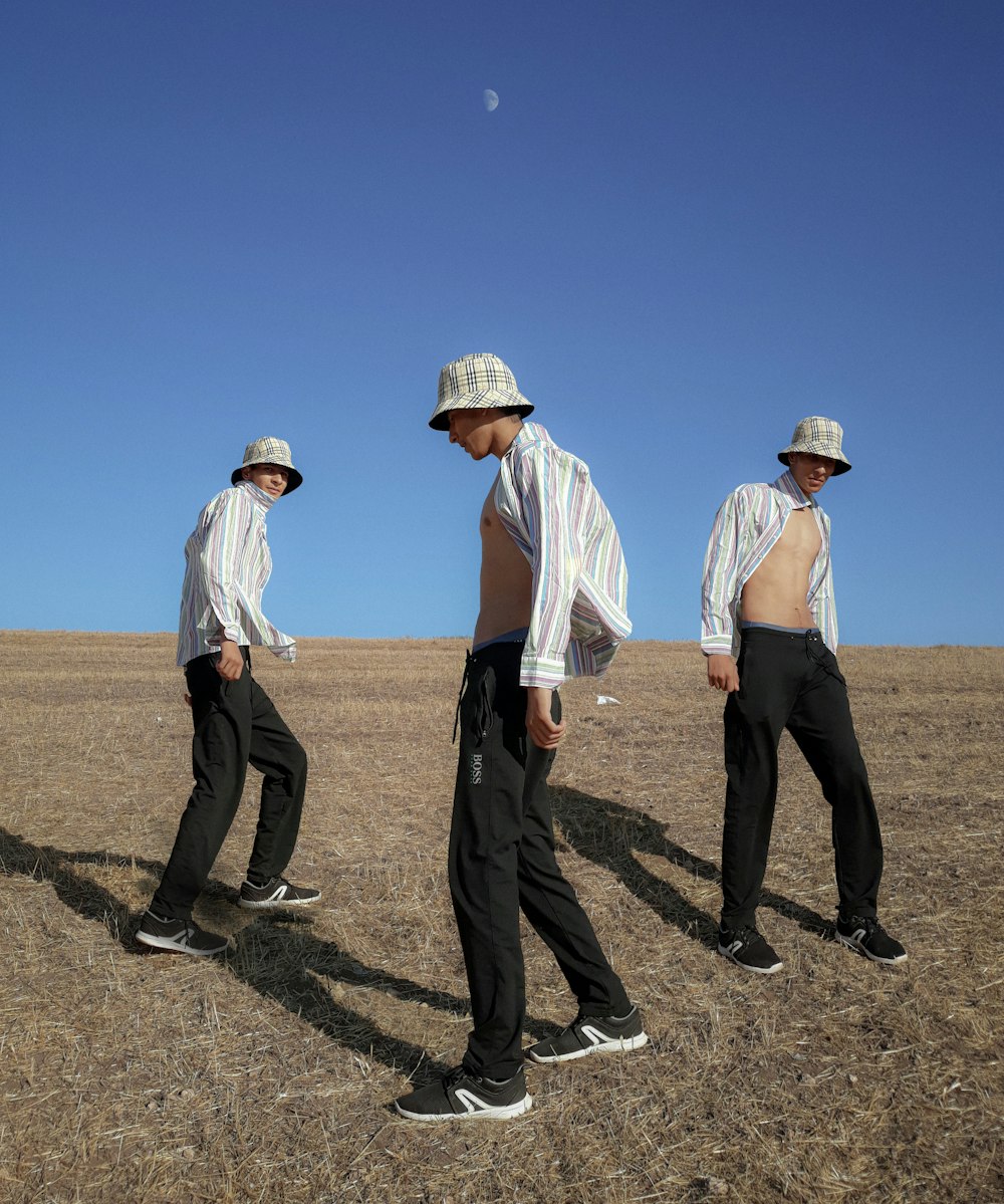 a group of men standing on top of a dry grass field