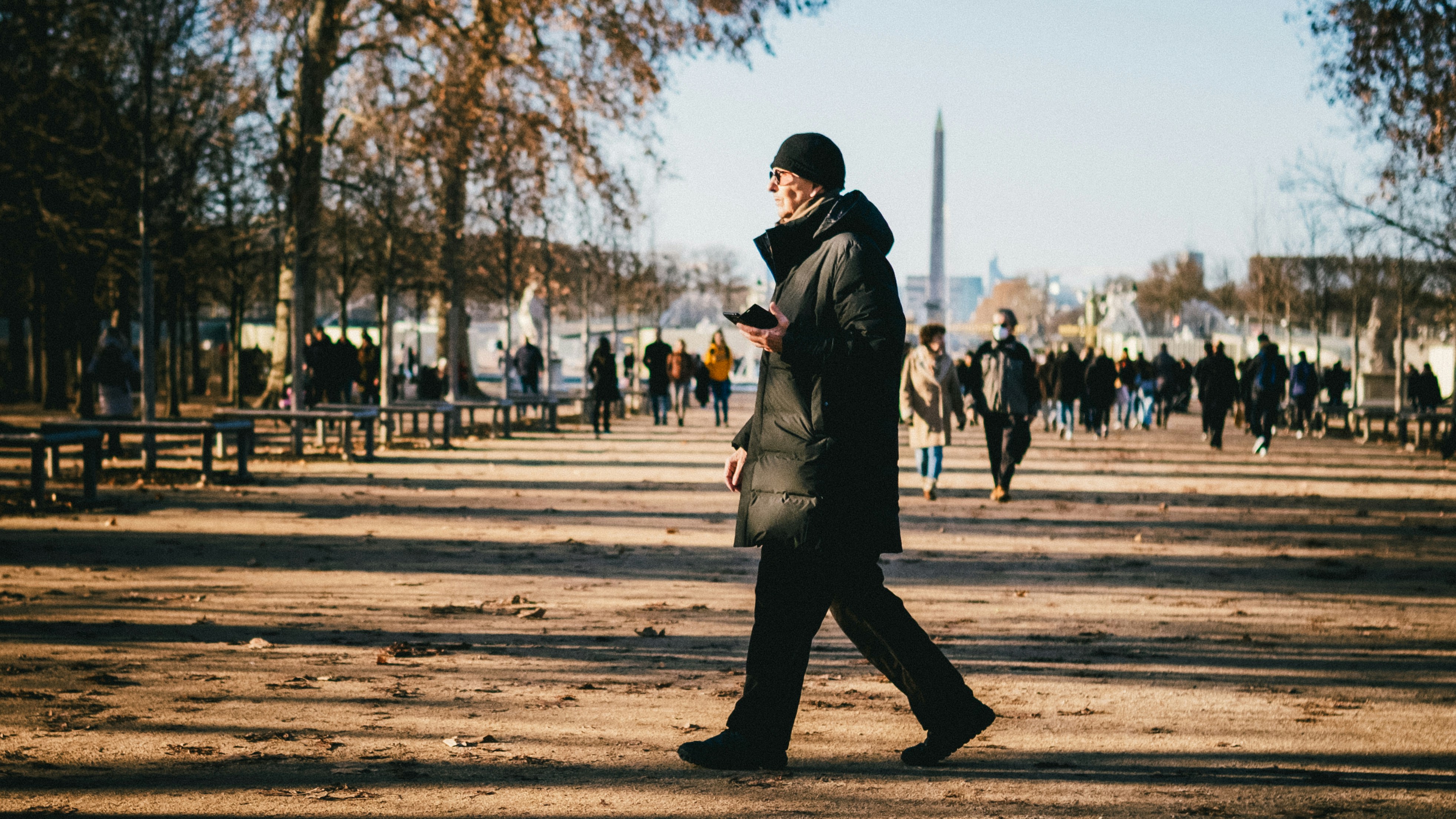 Worried dog owner checking smartphone for GPS location while walking down a street