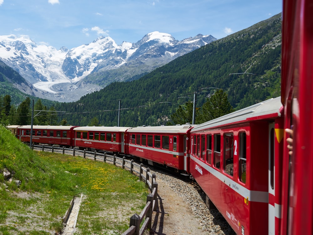 a red train traveling through a lush green countryside