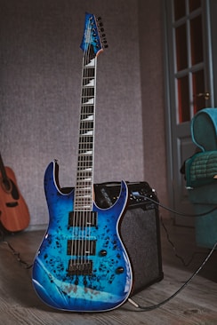 a blue guitar sitting on top of a wooden floor