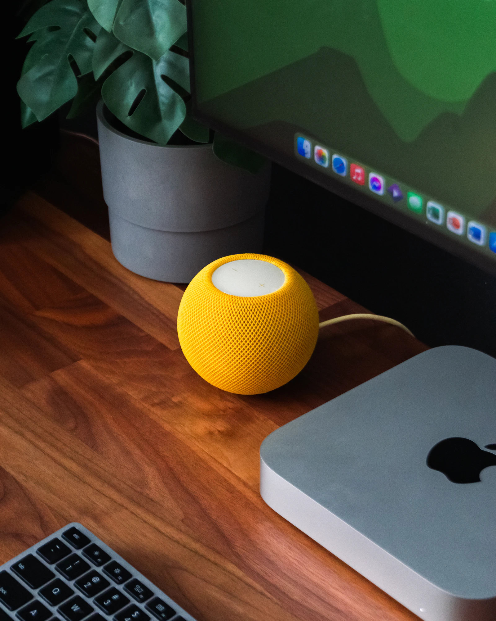 Compact wireless speaker positioned on a warm wooden desk