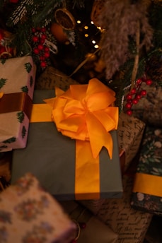 A beautifully wrapped Christmas gift surrounded by festive decorations and twinkling lights.