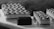 A selection of elegantly arranged desserts, including rectangular pastries with zigzag icing patterns and small chocolate-covered cubes, displayed on a light-colored surface. The image captures a monochromatic aesthetic with a focus on texture and detail.